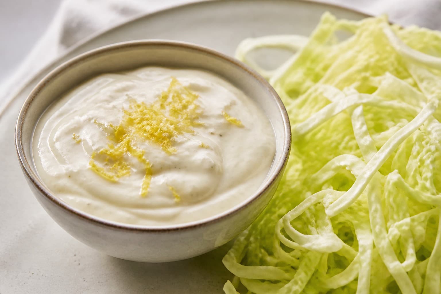 Skål med cremet mormordressing ved siden af spidskål