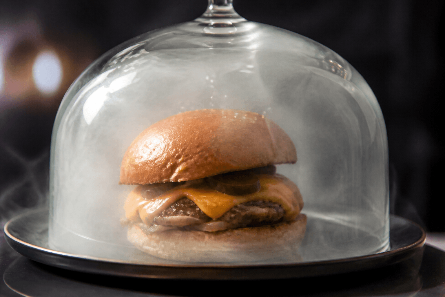 Cheeseburger under glasklokke med røg