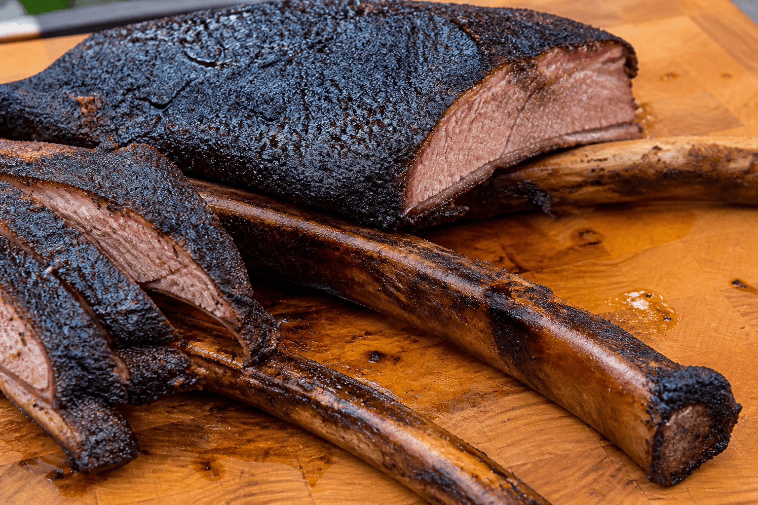 Smoked dino ribs med mørk bark på okseben